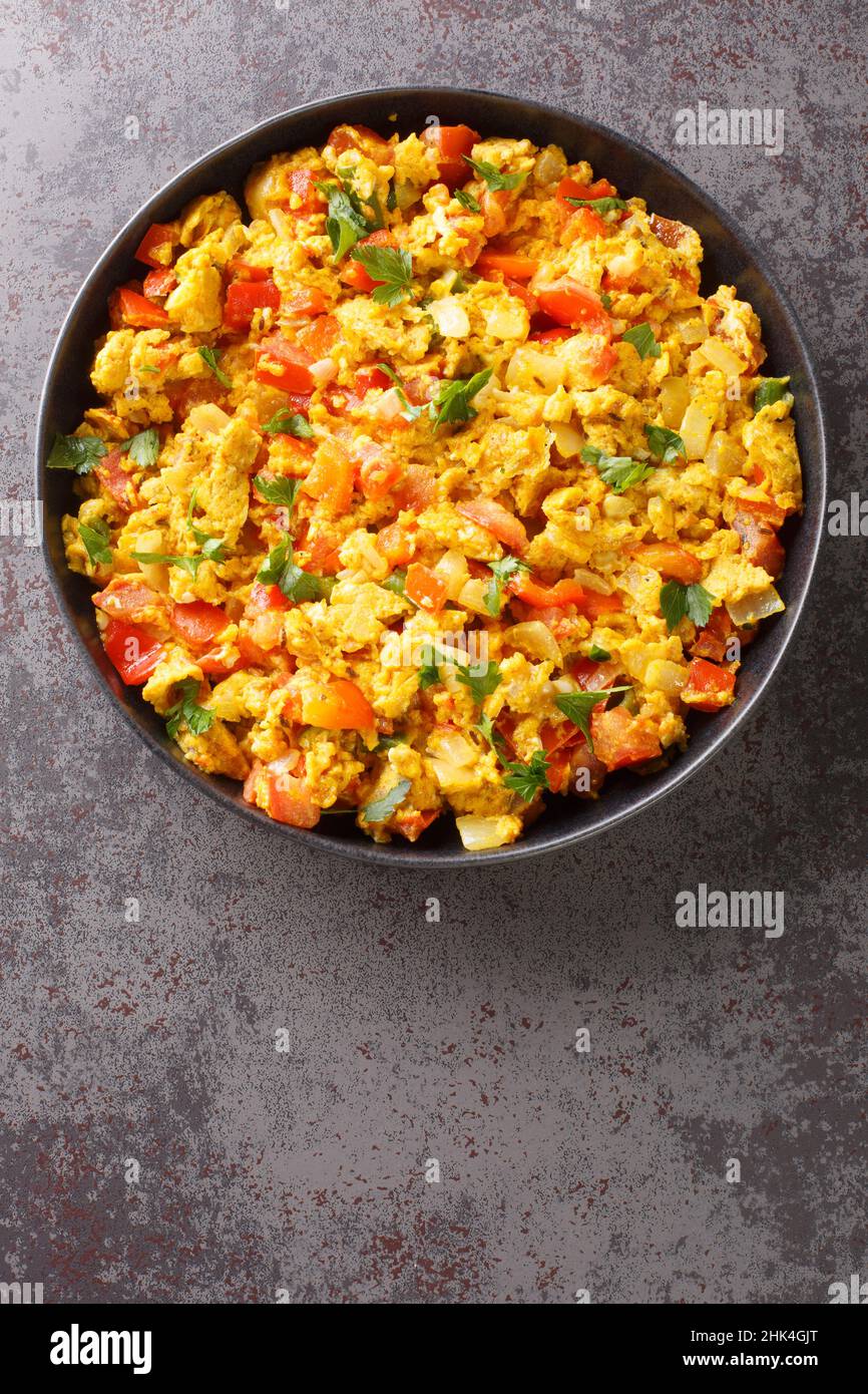 Anda Bhurji è uno stile indiano speziato uova strapazzate primo piano nel piatto sul tavolo. Vista dall'alto verticale Foto Stock