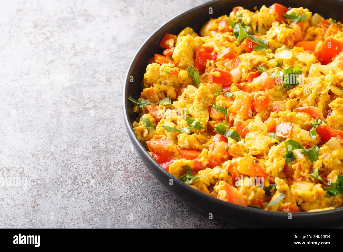 Uova Bhurji speziato indiano uova strapazzate primo piano nel piatto sul tavolo. Orizzontale Foto Stock