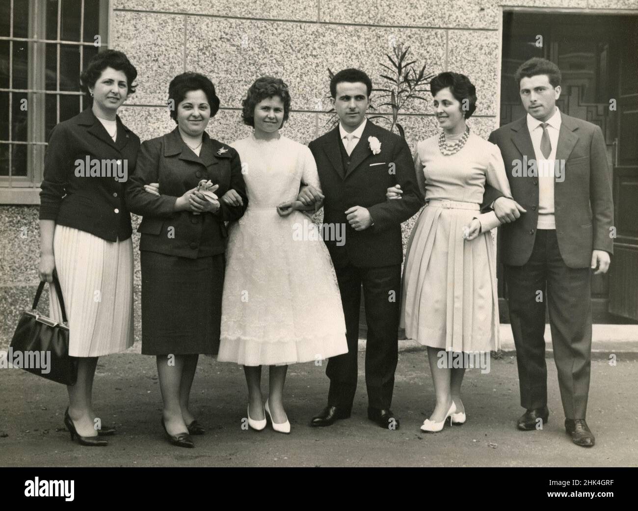 Matrimonio in Italia durante il 1950s: La sposa e lo sposo fanno la foto con i parenti Foto Stock