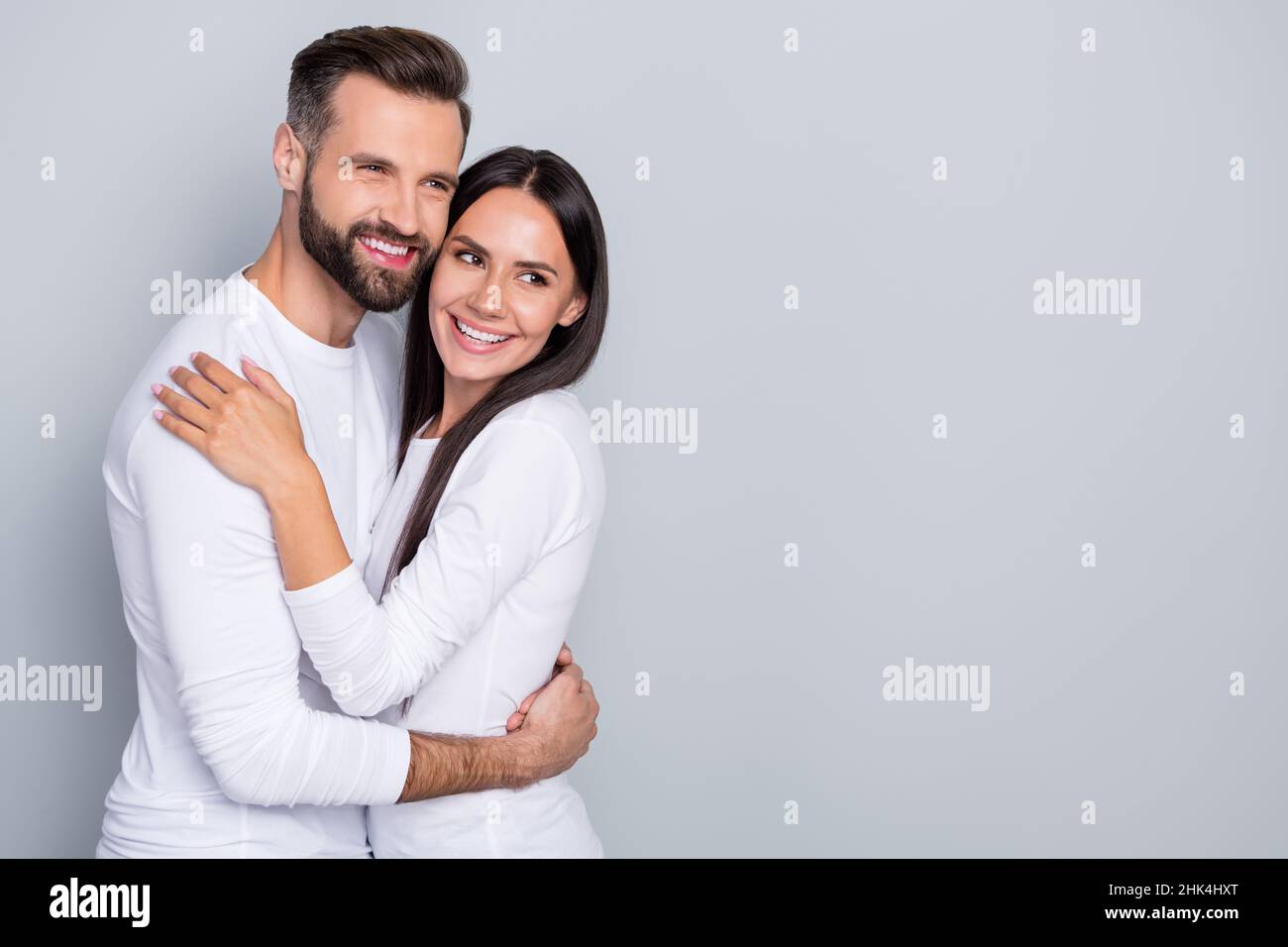 Foto di ragazzo sognante signora vestito camicie bianche cercando spazio vuoto abbracciando isolato grigio sfondo di colore Foto Stock