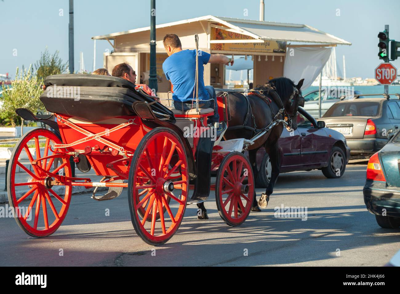 Zante, Grecia - 14 agosto 2016: Una carrozza trainata da cavalli rosso aperta con turisti e un cocchiere, vista posteriore Foto Stock