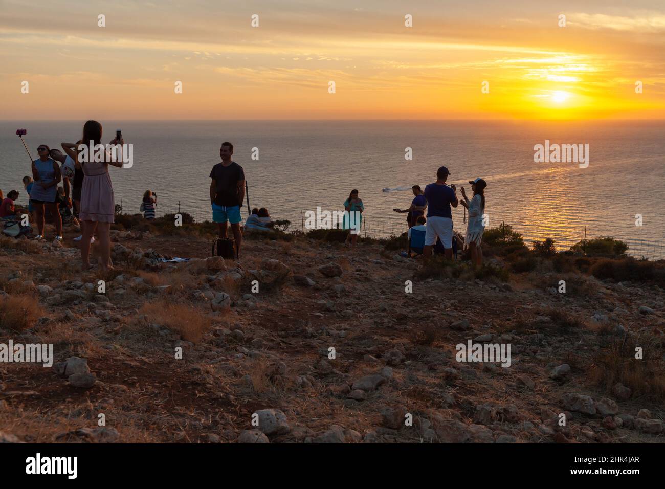 Zante, Grecia - 19 agosto 2016: I turisti scattano foto del tramonto colorato a Capo Keri. Isola greca di Zante, Mar Ionio Foto Stock