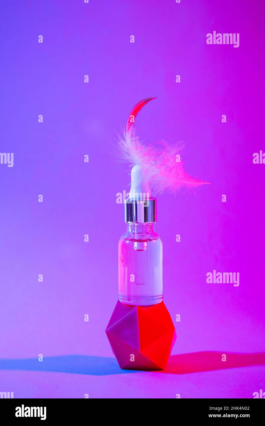 Flacone di siero cosmetico in luce al neon Foto Stock