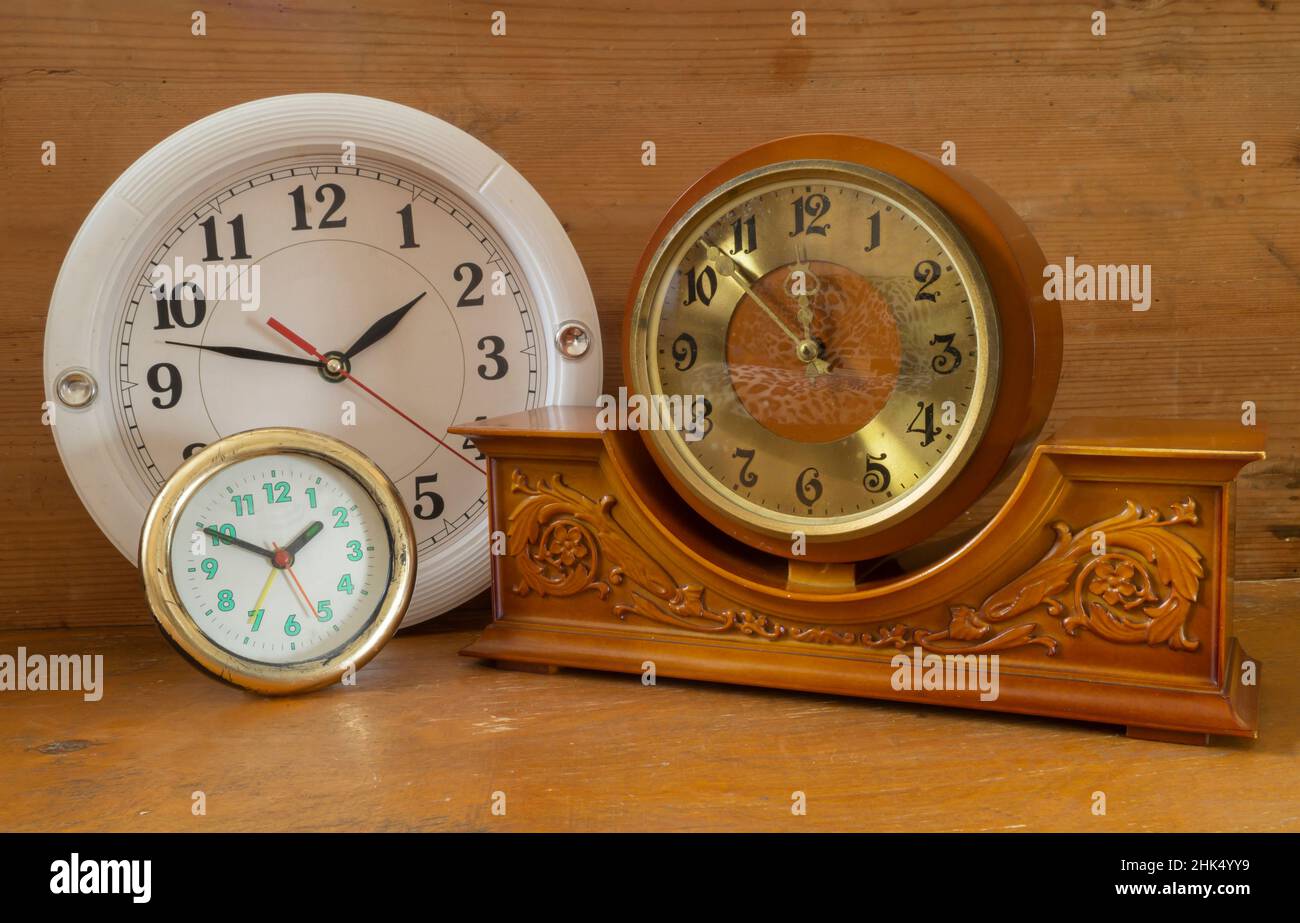 Antico orologio meccanico in legno sul ripiano. Primo piano degli oggetti di casa Foto Stock