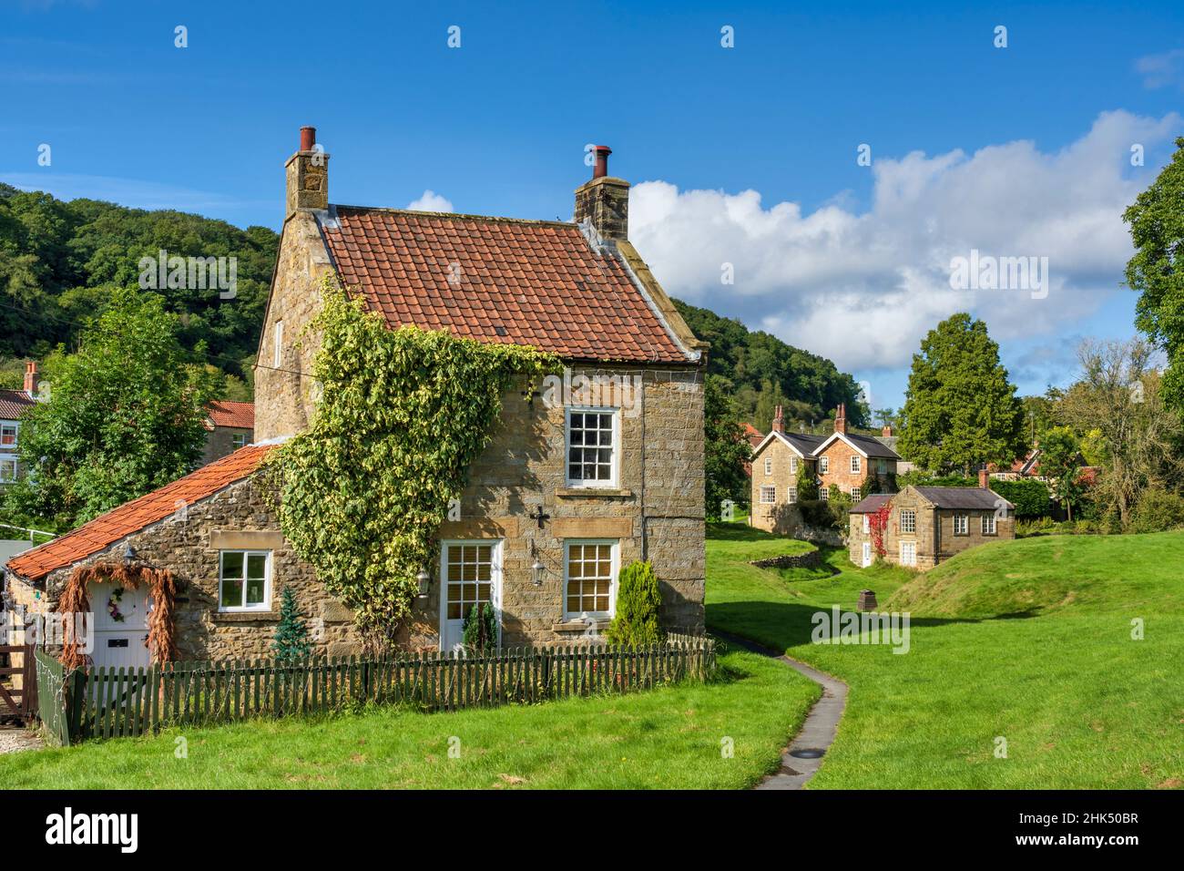 Case in pietra intorno al villaggio verde a Moorland villaggio di Hutton le Hole sul North Yorkshire Moors, Yorkshire, Inghilterra, Regno Unito, Europa Foto Stock