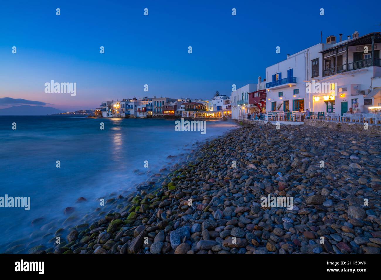 Vista dei ristoranti e della spiaggia di ciottoli a Little Venice nella città di Mykonos di notte, Mykonos, Isole Cicladi, Isole Greche, Mar Egeo, Grecia, Europa Foto Stock