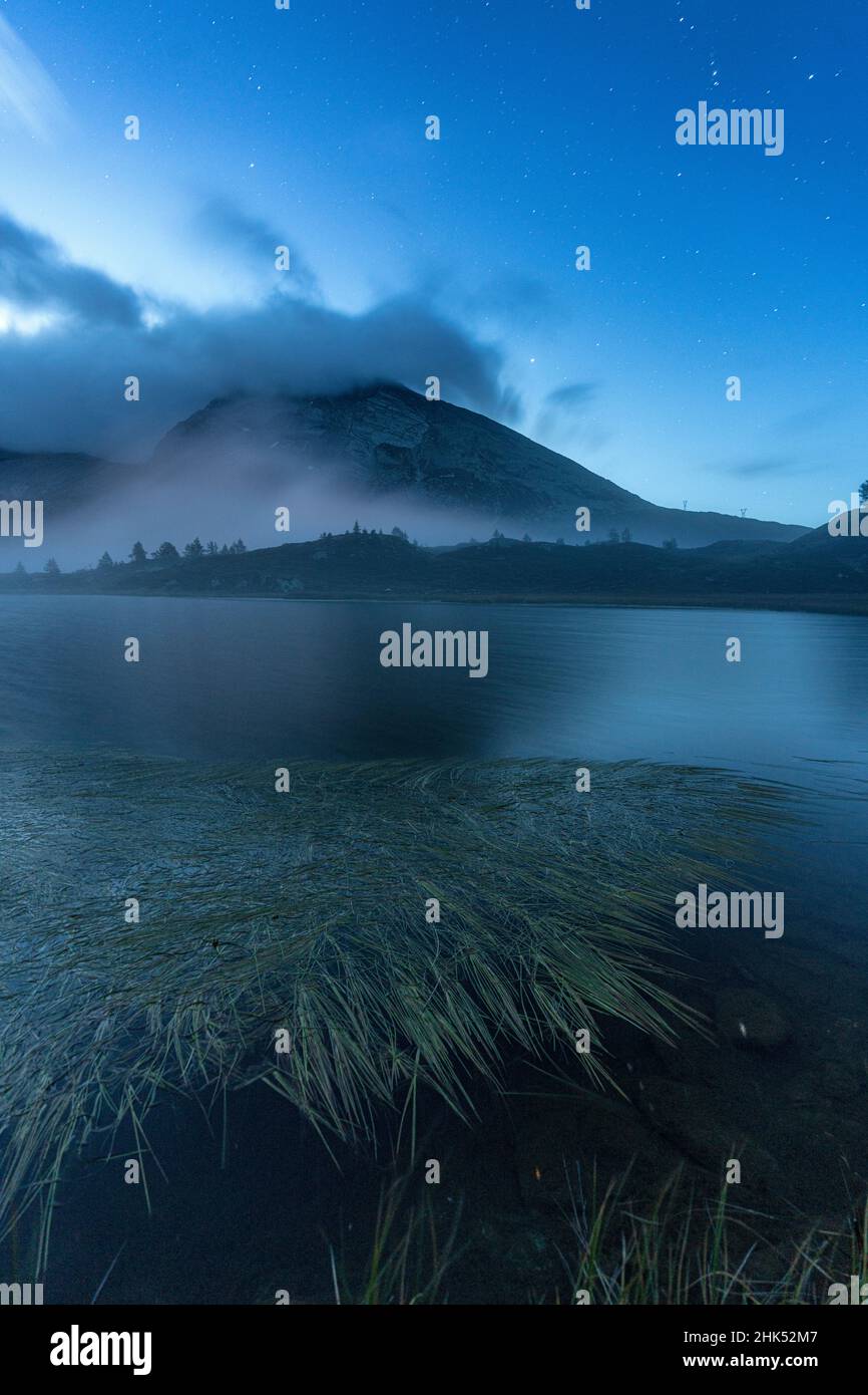 Acque calme del lago Hopschusee durante l'ora blu, Passo del Sempione, Canton Vallese, Alpi svizzere, Svizzera, Europa Foto Stock