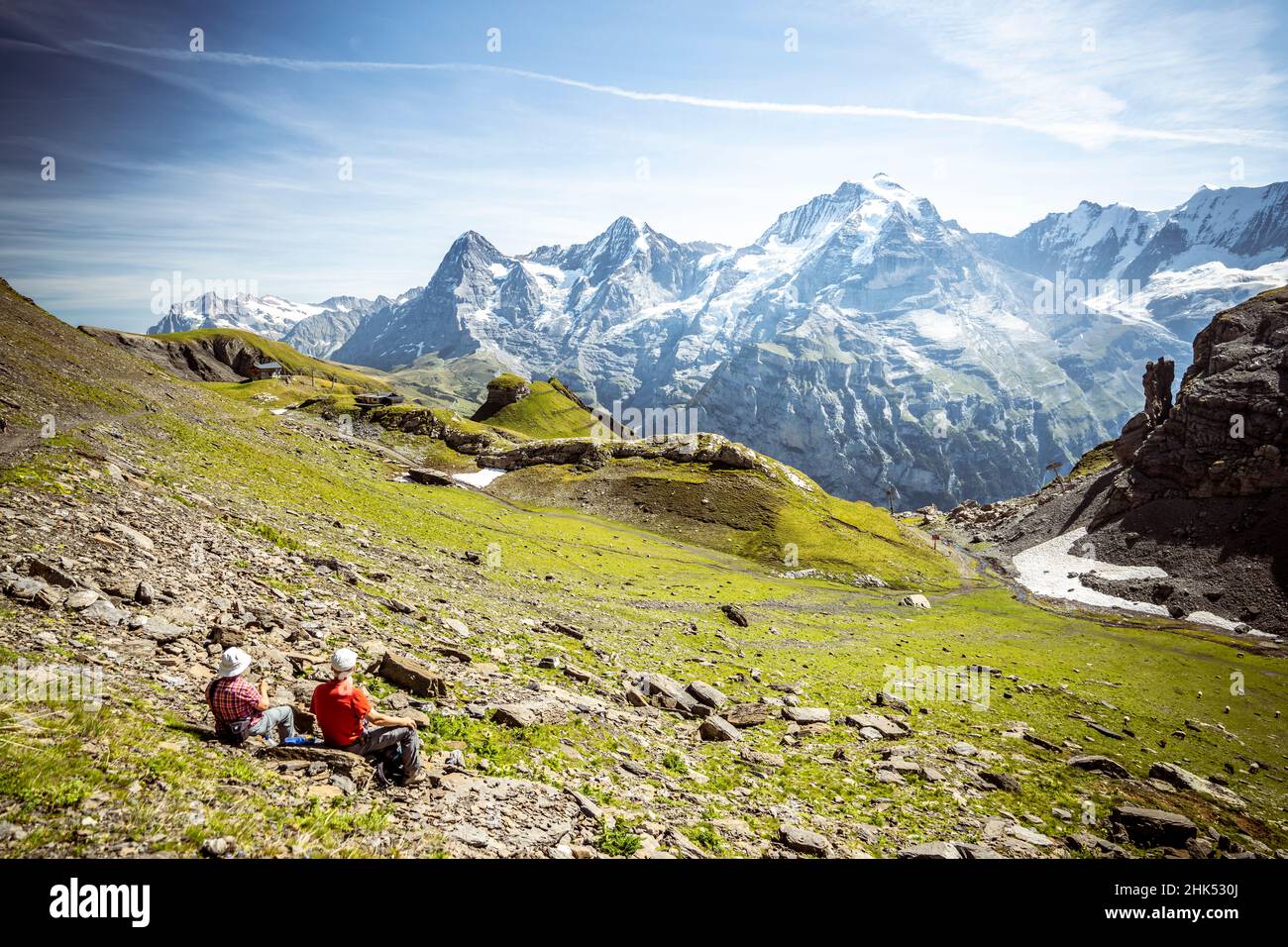 Due persone che ammirano i monti Eiger, Monch e Jungfrau dai prati, Murren Birg, Jungfrau, Berna Canton, Alpi svizzere, Svizzera, Europa Foto Stock