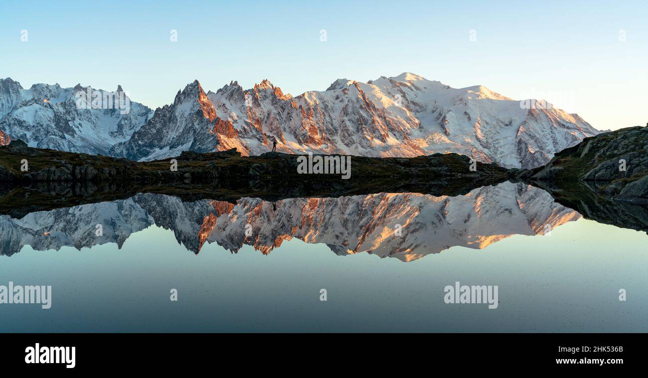 Escursionista ammirando Dent du Geant e Monte Bianco coperto di neve riflessa in Lacs des Cheserys al tramonto, Haute Savoie, Alpi francesi, Francia, Europa Foto Stock