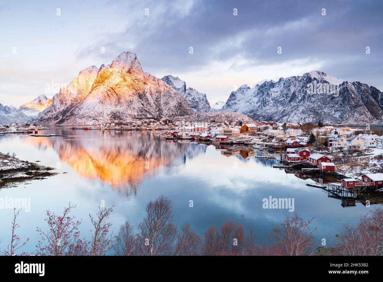 Cabine rosse di Rorbu sul mare con il Monte Olstind sullo sfondo, Reine Bay, Isole Lofoten, Norvegia, Scandinavia, Europa Foto Stock