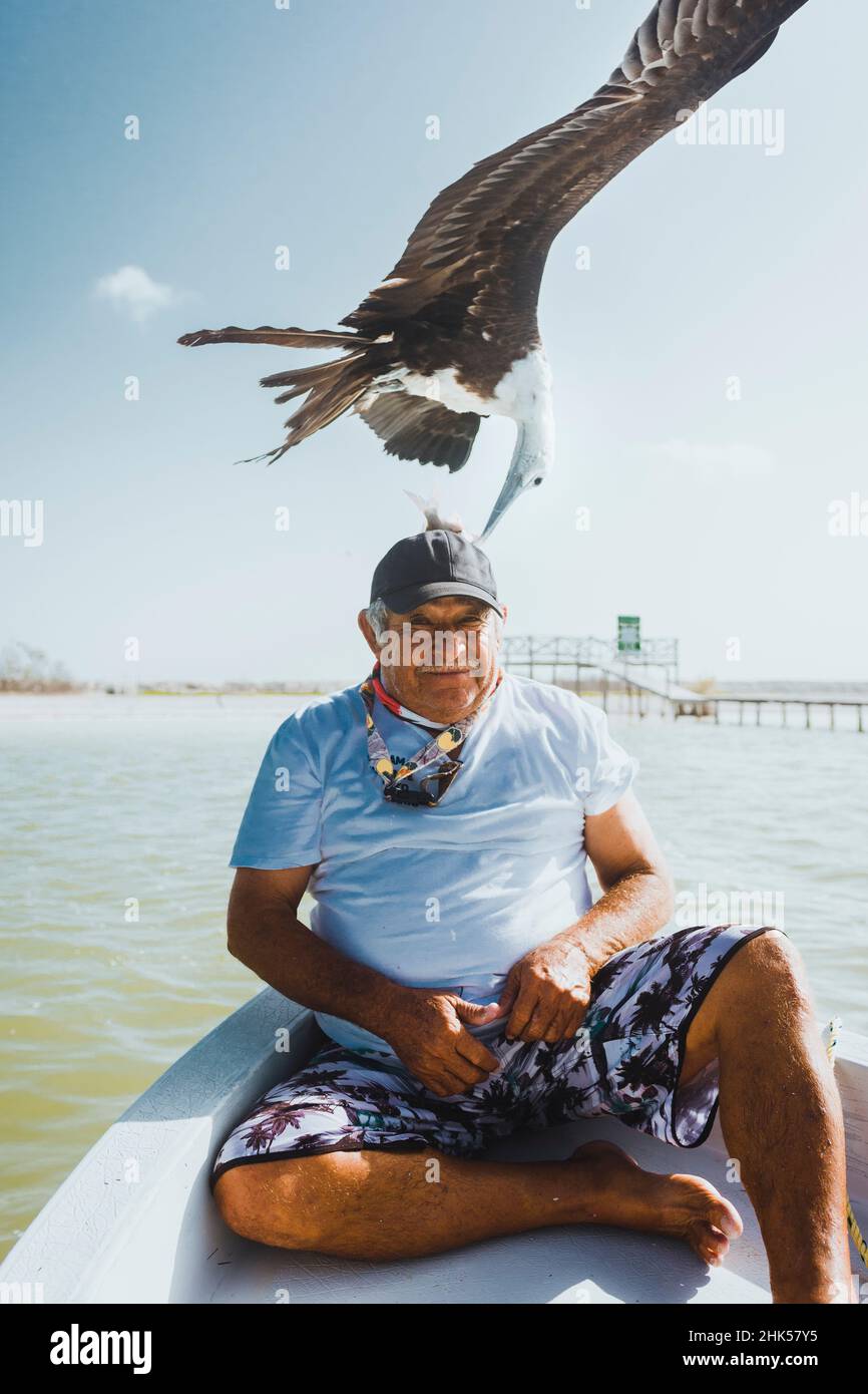 Vecchio uomo messicano che alimenta gli uccelli sulla sua testa Foto Stock