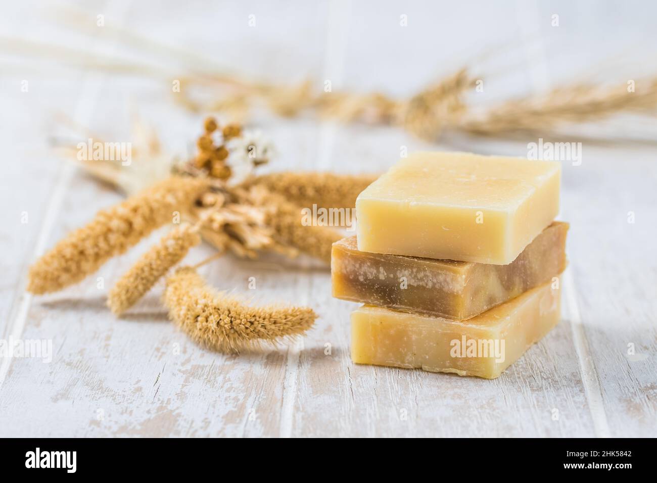 Tre pezzi di sapone naturale su sfondo bianco in legno, concetto di benessere Foto Stock