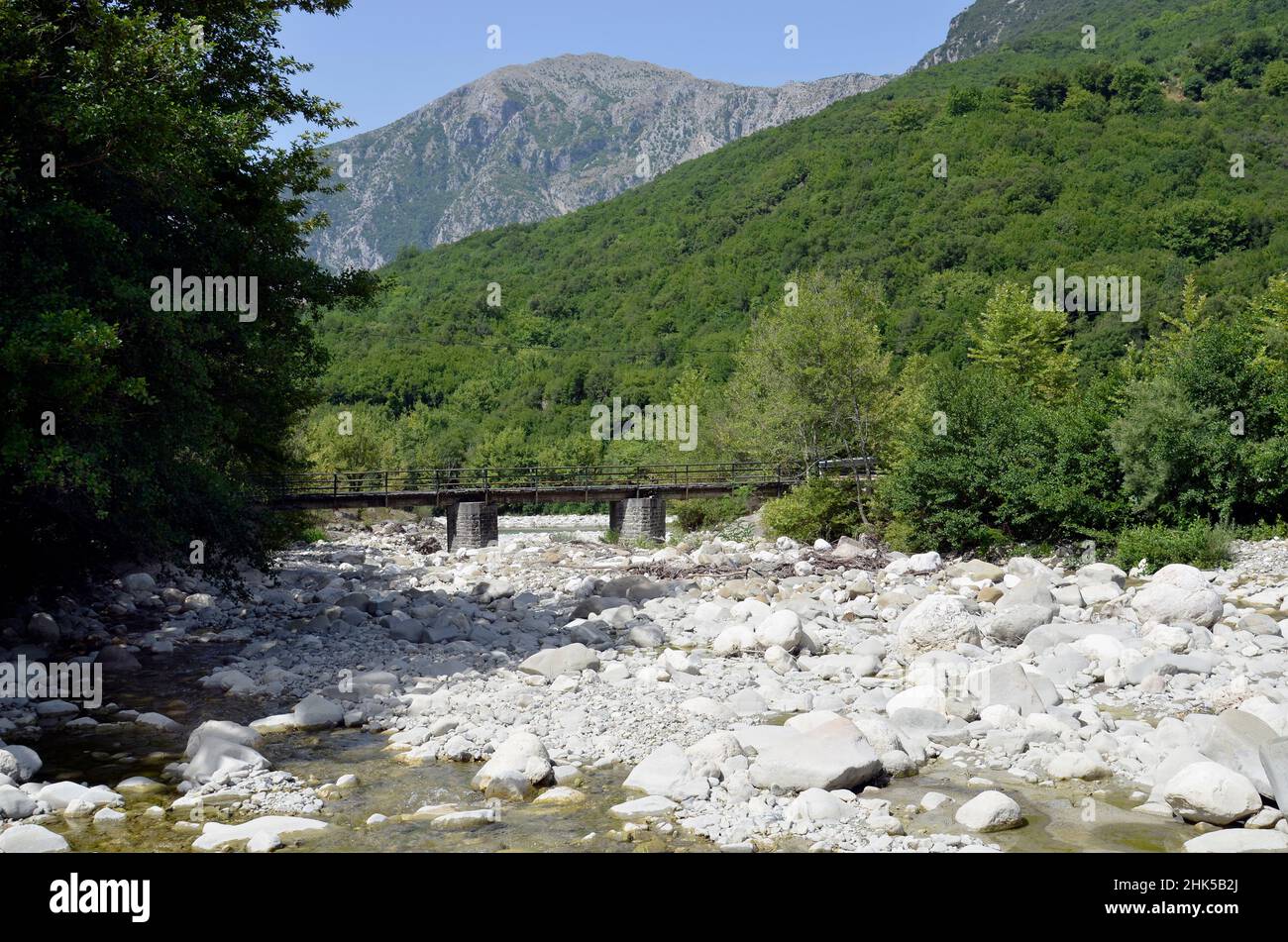 Grecia, massi e pietre nel letto del fiume e un ponte a corsia unica su un ramo del fiume Arachthos nel Parco Nazionale di Tzoumerka- Peristeri- Foto Stock