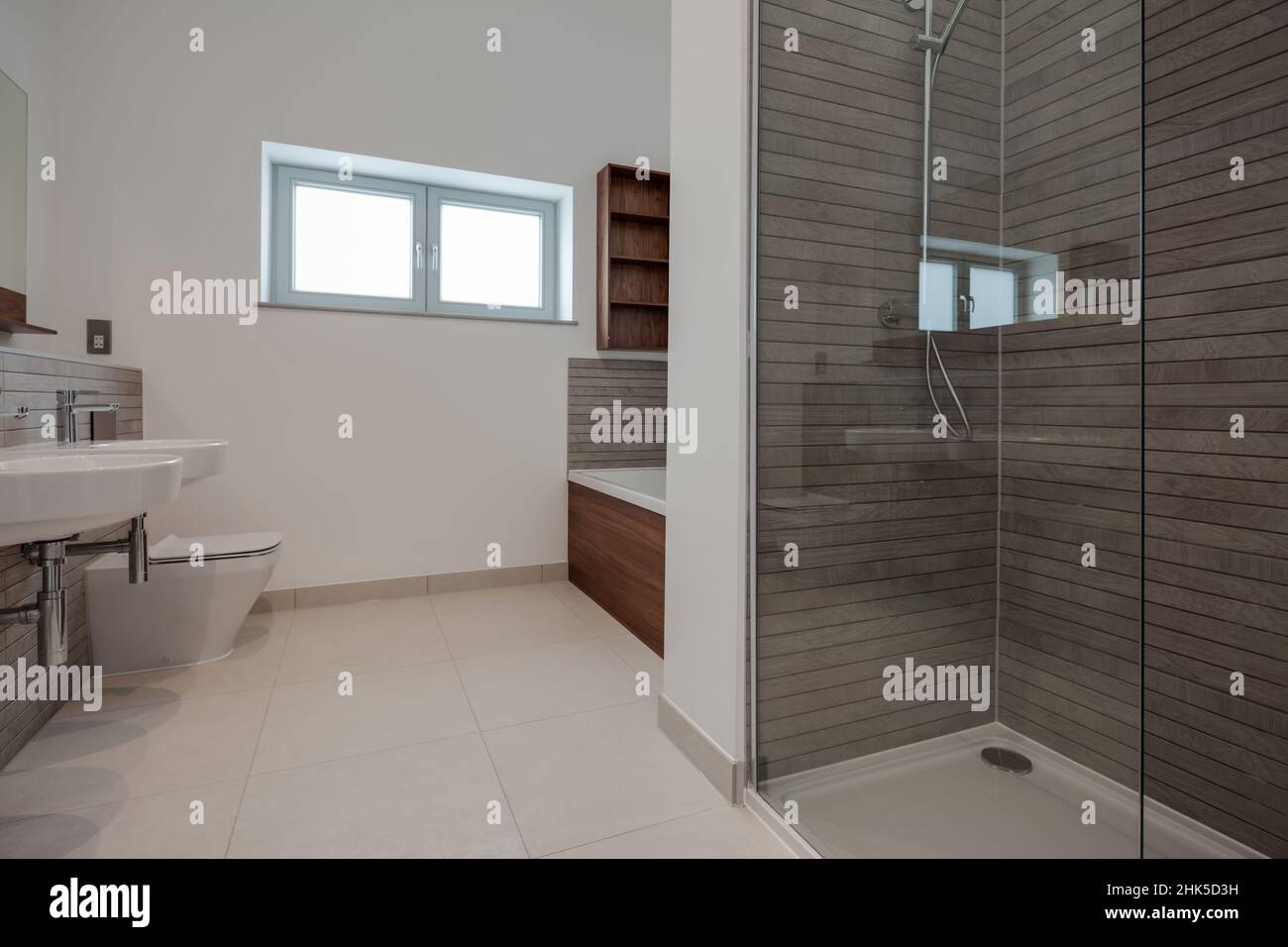 Trumpington, Cambridgeshire - Maggio 04 2017: Camera da bagno minimalista di lusso contemporaneo con doccia all'interno di una nuova casa con pareti piastrellate e dipinte di bianco Foto Stock