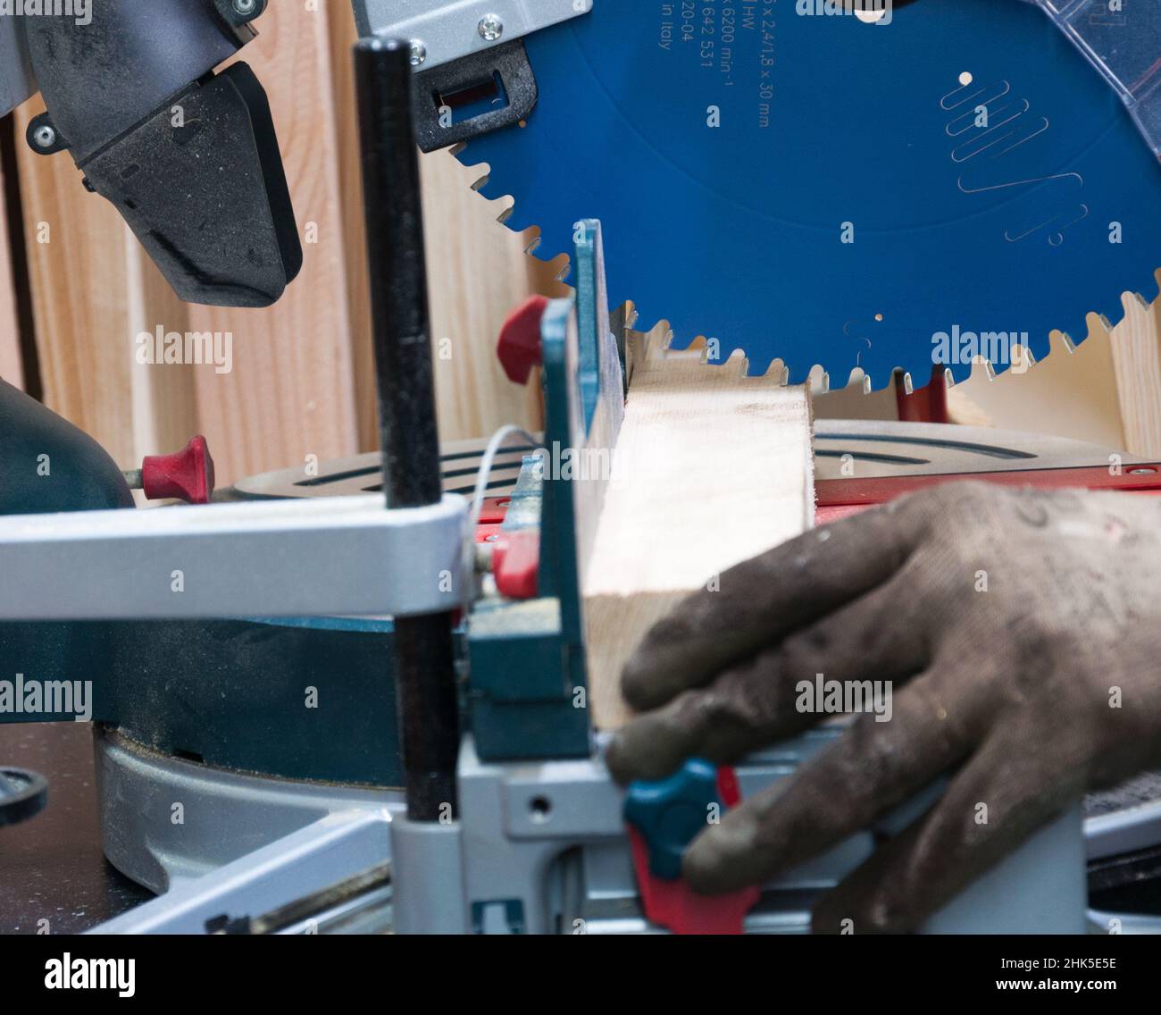 l'operaio taglia un pezzo di legno con la sega circolare. Foto Stock