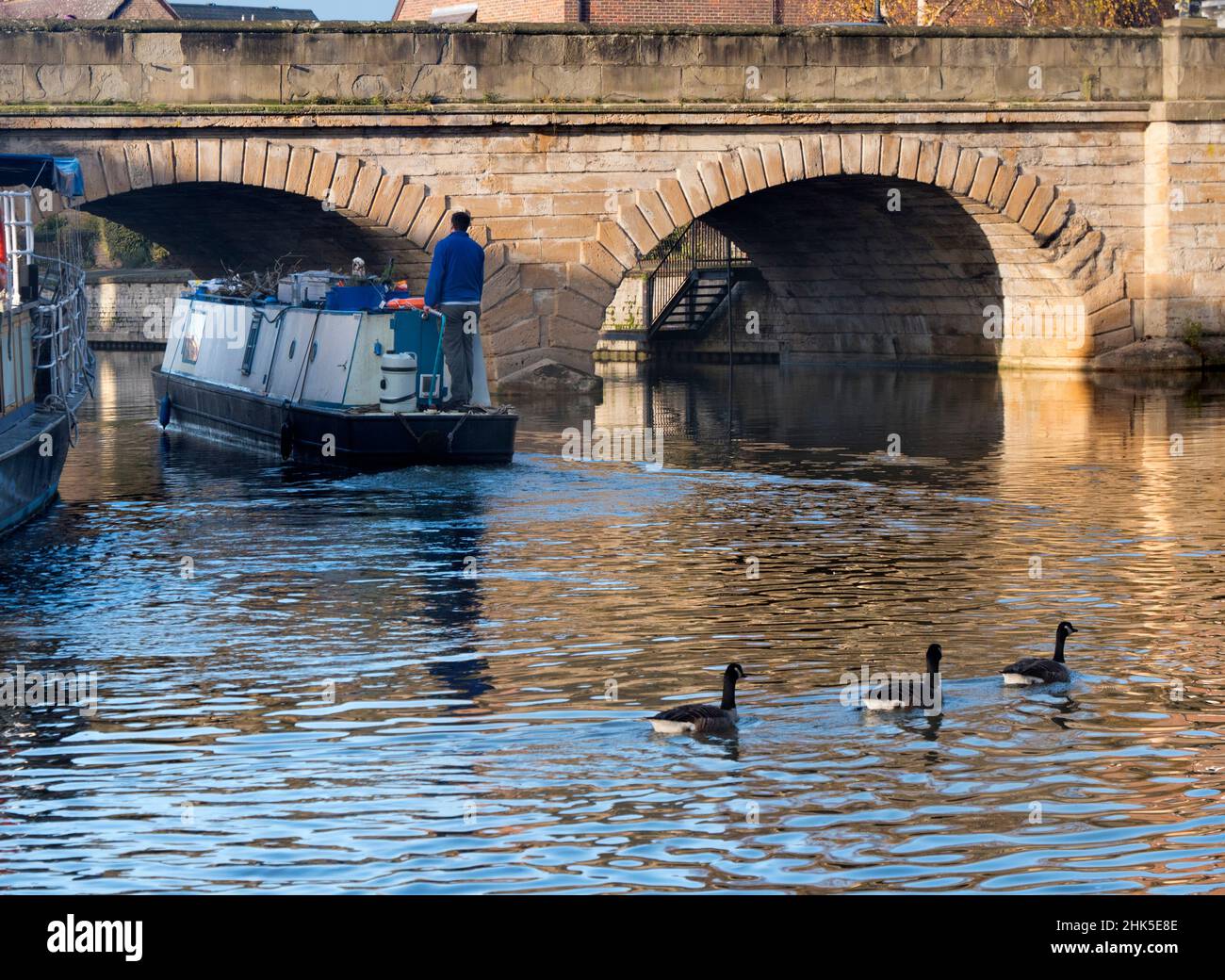 Una scena tranquilla vicino al Tamigi a Oxford, mentre una casa galleggiante passa sotto il Folly Bridge in una luminosa mattinata invernale. Questo ponte di pietra, eretto dal 1825-27, c Foto Stock