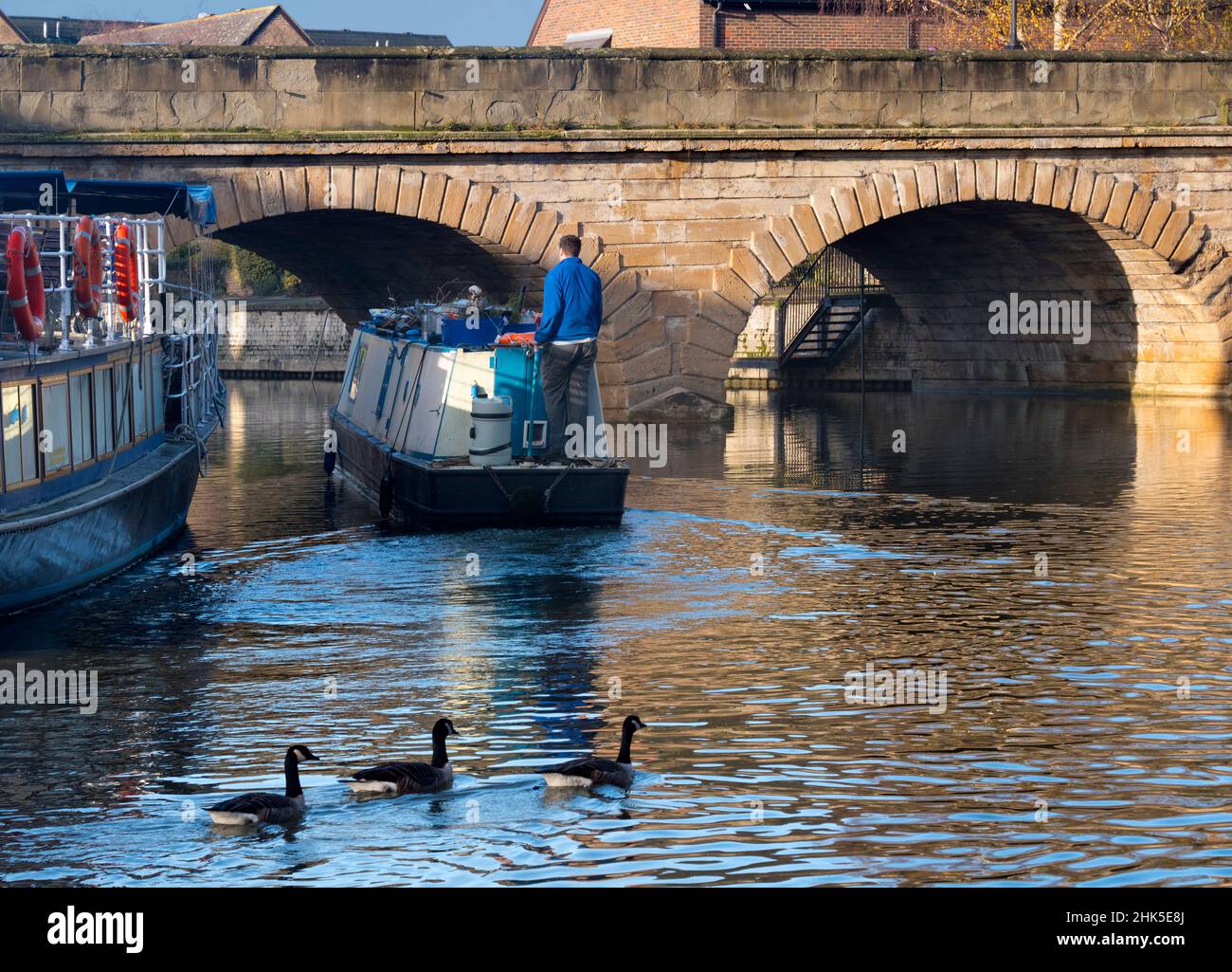 Una scena tranquilla vicino al Tamigi a Oxford, mentre una casa galleggiante passa sotto il Folly Bridge in una luminosa mattinata invernale. Questo ponte di pietra, eretto dal 1825-27, c Foto Stock