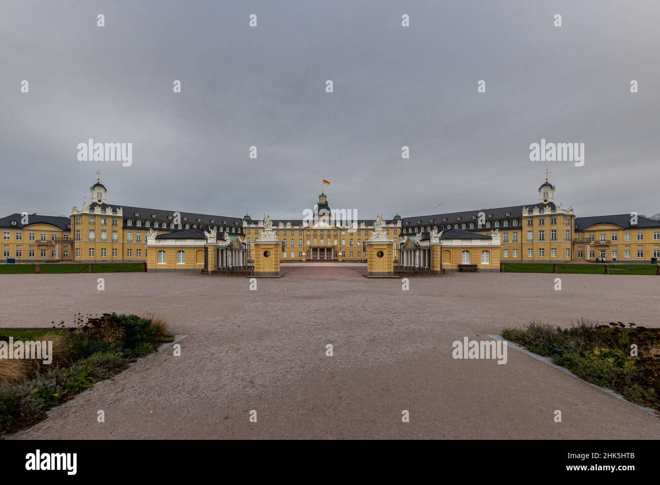 Vista frontale del Castello di Karlsruhe con un cielo suggestivo e nuvoloso. Foto Stock