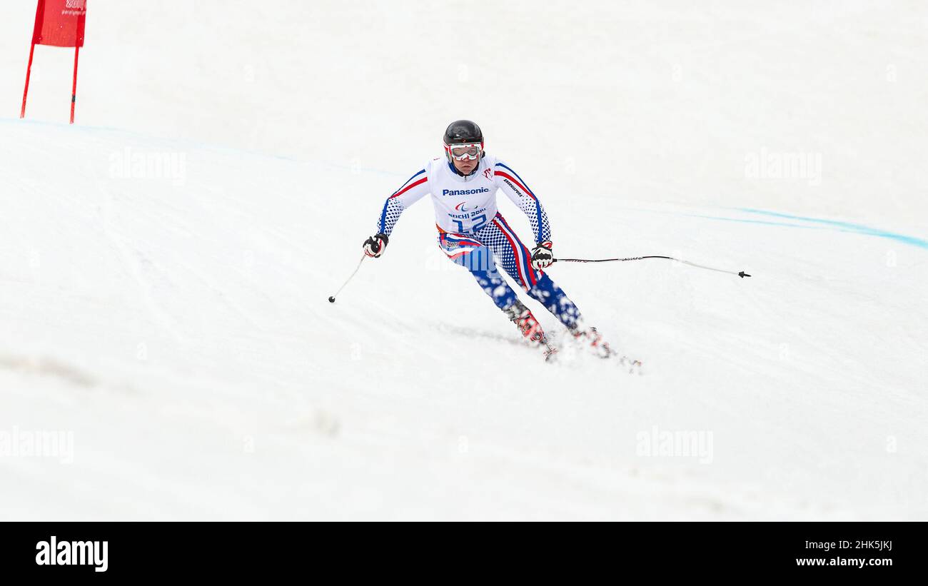 Valerii REDKOZUBOV di Russia segue le grida della sua guida nella Slalom gigante dello Sci Alpino Mens durante i Giochi Paralimpici invernali del Ros 2014 Foto Stock