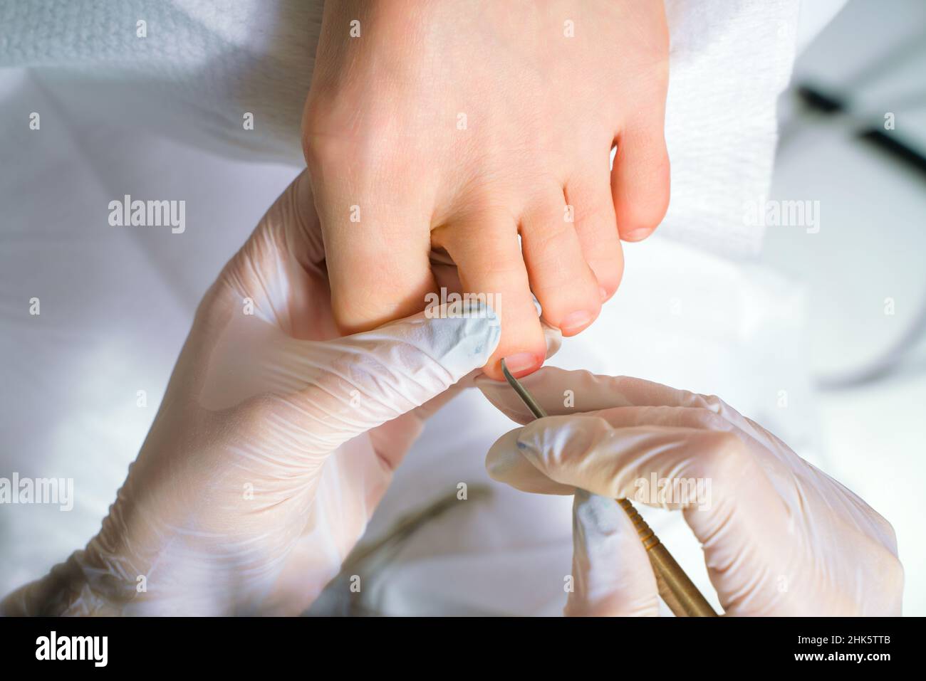 Un medico di podiatrist che si prende cura delle toenails di una donna. Procedure cosmetiche dei piedi Foto Stock
