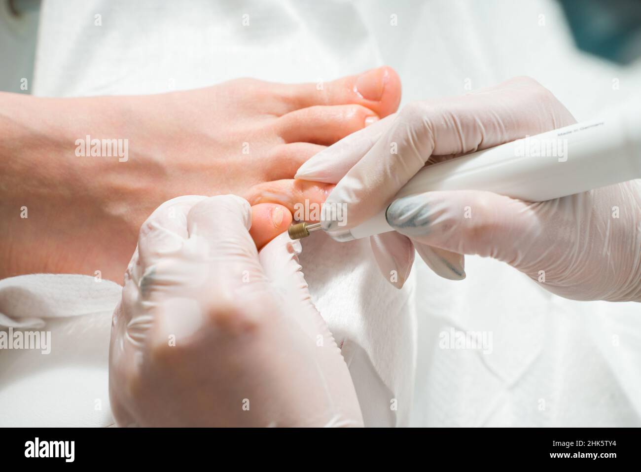 Un medico di podiatrist che si prende cura delle toenails di una donna. Procedure cosmetiche dei piedi Foto Stock