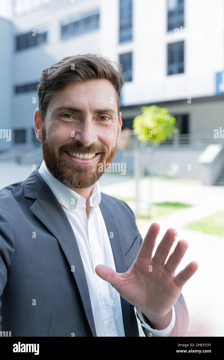 Fotocamera per smartphone con vista verticale uomo d'affari caucasico parla al telefono utilizzando una fotocamera frontale durante una videochiamata. Uomo d'affari dipendente che parla con w Foto Stock