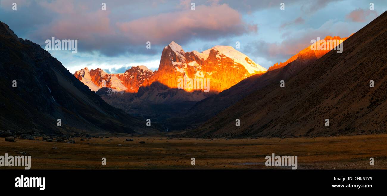 Panorama di tramonto spettacolare nelle montagne innevate e valle nel remoto circuito di Cordillera Huayhuash vicino Caraz in Perù. Foto Stock