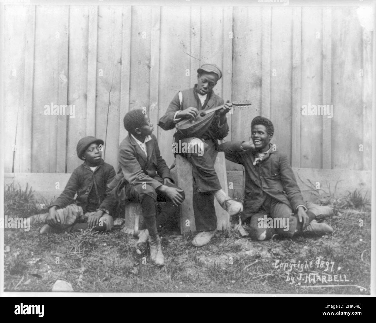 Quattro ragazzi afroamericani, uno che suona il liuto - circa 1897 Foto Stock