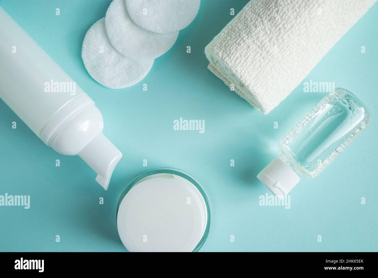 Prodotti cosmetici e accessori spa su sfondo blu. Crema, sapone e asciugamano. Cura della pelle, concetto di benessere. Spazio di copia. Foto Stock
