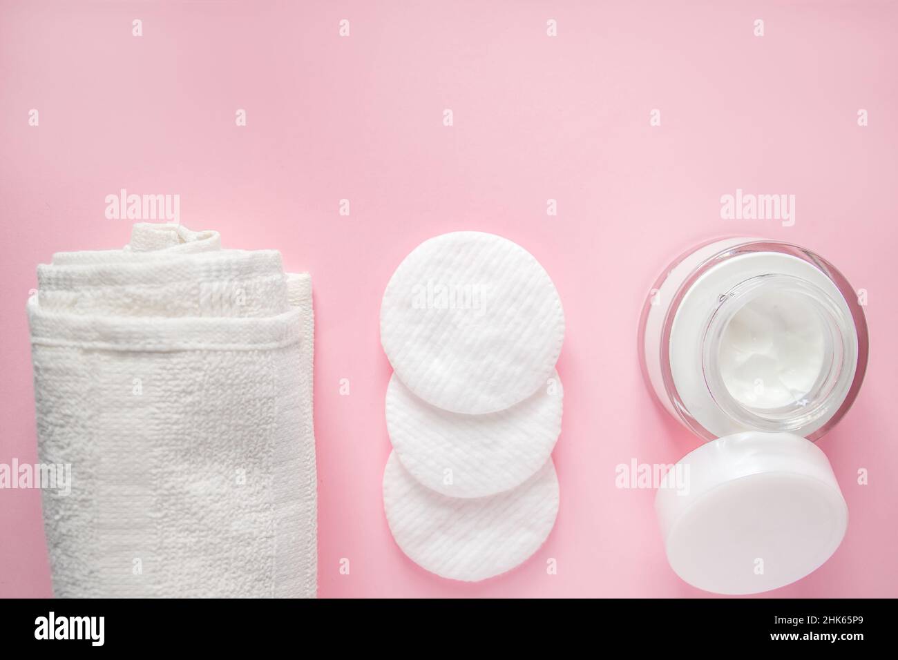 Prodotti cosmetici su sfondo rosa. Sapone, lozione e tamponi di cotone. Accessori per il centro benessere. Concetto di benessere. Foto Stock