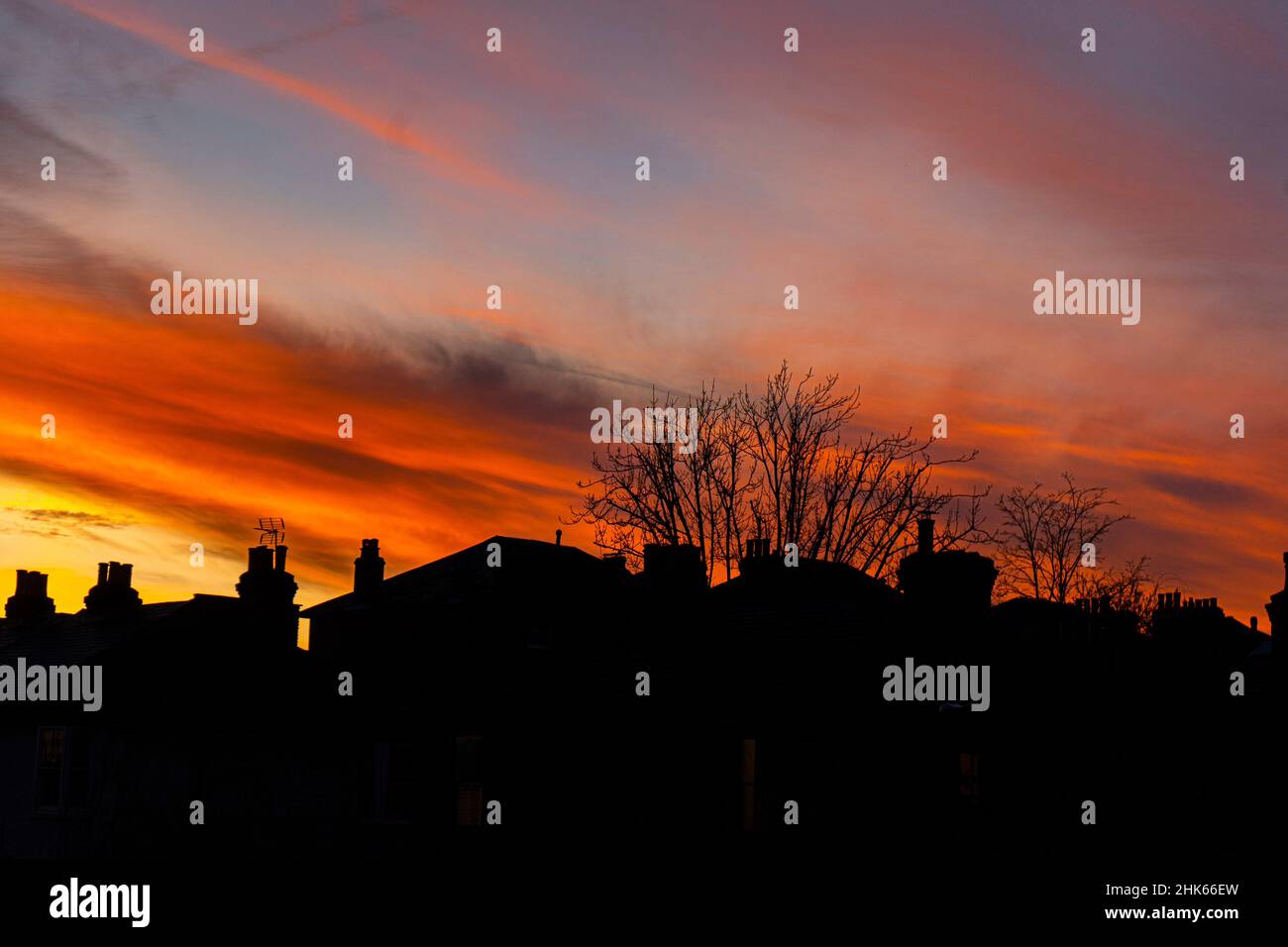WIMBLEDON LONDRA, REGNO UNITO. 2 Febbraio, 2022. Le case residenziali si staglia contro un fuoco al tramonto su Wimbledon, a sud-ovest di Londra. Credit: amer Ghazzal/Alamy Live News Foto Stock