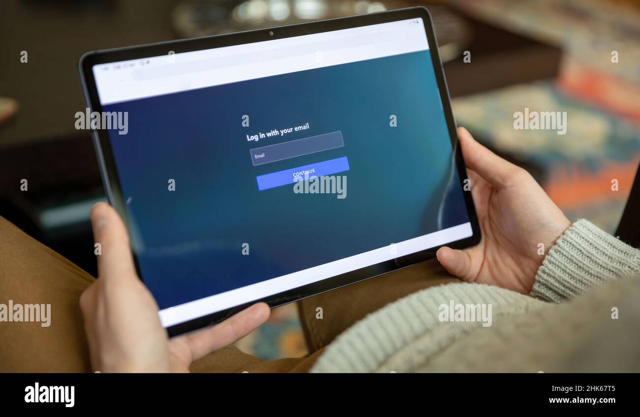 Accedi con la tua e-mail, il messaggio sullo schermo di un tablet digitale e accedi a un sistema informatico. Dispositivo portatile con presa a mano maschio Foto Stock