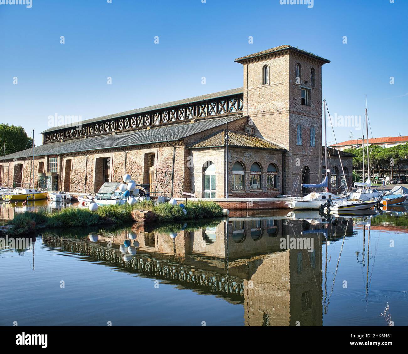 Magazzini salini e barche ormeggiate nel colorato porto del canale di Cervia, Emilia Romagna, Italia Foto Stock