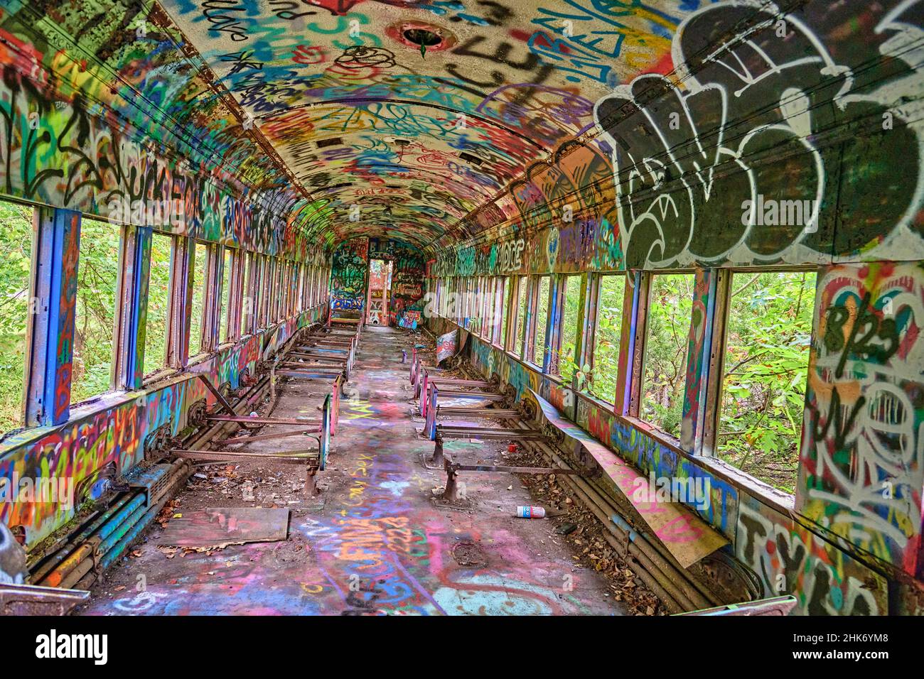 All'interno di un treno abbandonato con graffiti colorati. Preso su un angolo per effetto. Foto Stock