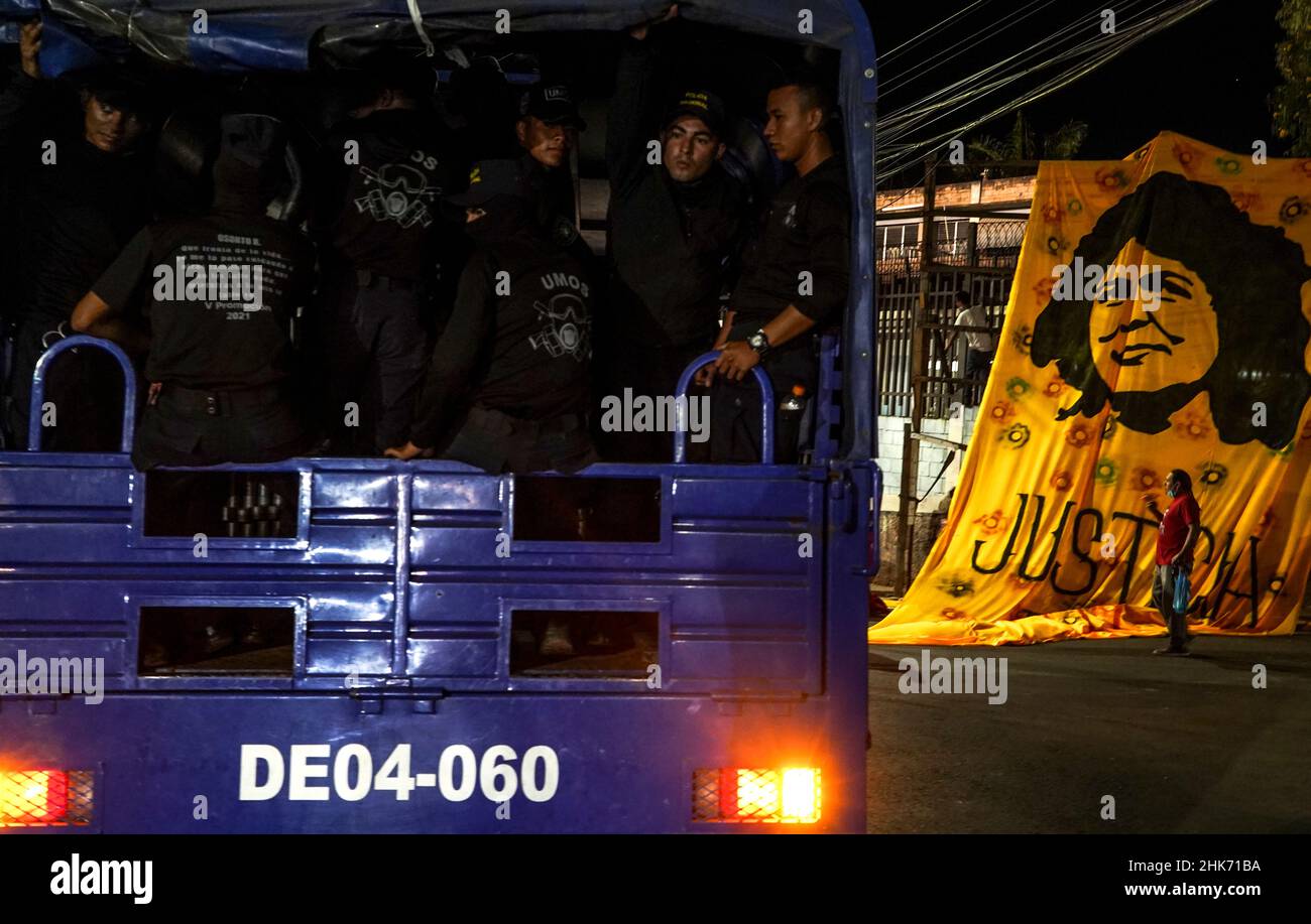 Tegucigalpa, Honduras. 27th Jan 2022. Le unità di controllo di riot siedono su un camion mentre i sostenitori DI LIBRE appendono un banner raffigurante l'assassino, il combattente sociale Berta Cacerez. Xiomara Castro è la prima donna a diventare presidente dell'Honduras, governando con IL Partito LIBRE (Libertad y Refundación) ha proposto riforme sociali per il suo mandato. (Foto di Camilo Freedman/SOPA Images/Sipa USA) Credit: Sipa USA/Alamy Live News Foto Stock