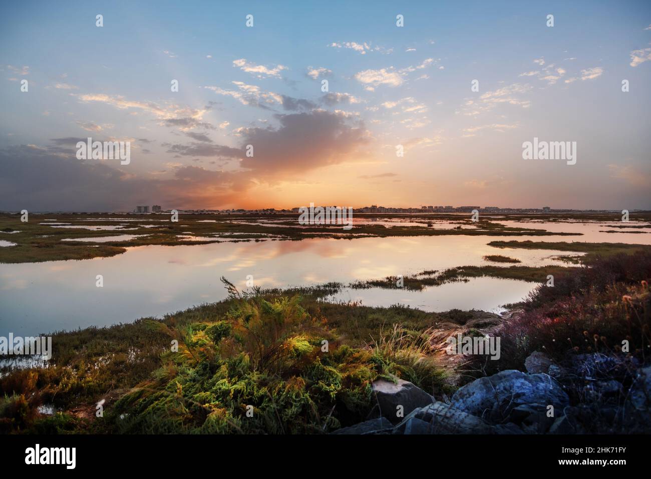 Vista di Punta Umbria dalle paludi di Huelva Spagna, in un bellissimo tramonto con un cielo pieno di nuvole Foto Stock