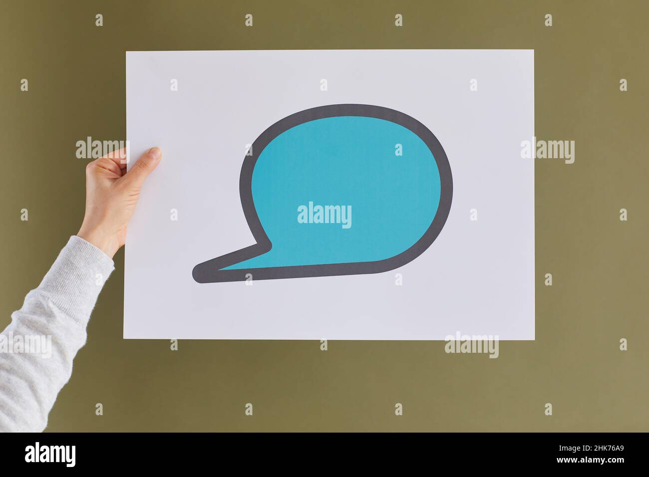 White paper con icone di chat blu disegnate accanto a una donna sconosciuta su sfondo verde. Foto Stock