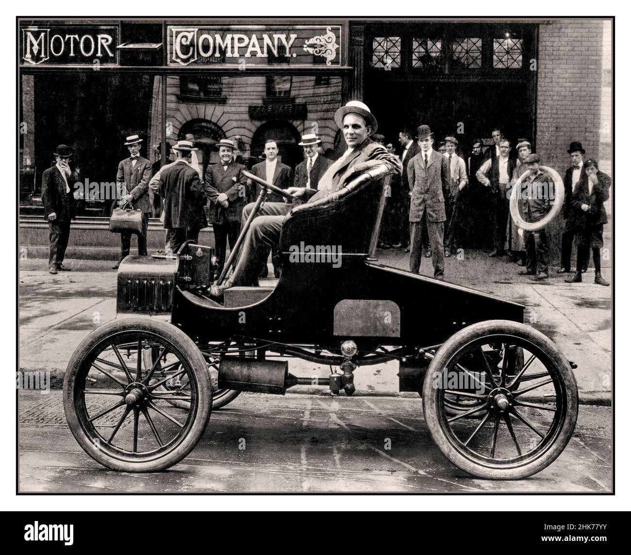1900s Henry Ford nel sedile di guida di uno dei suoi primi motori a benzina c1901 fuori dalla sua Ford Motor Company showroom con amici e colleghi dietro Detroit Michigan USA Foto Stock