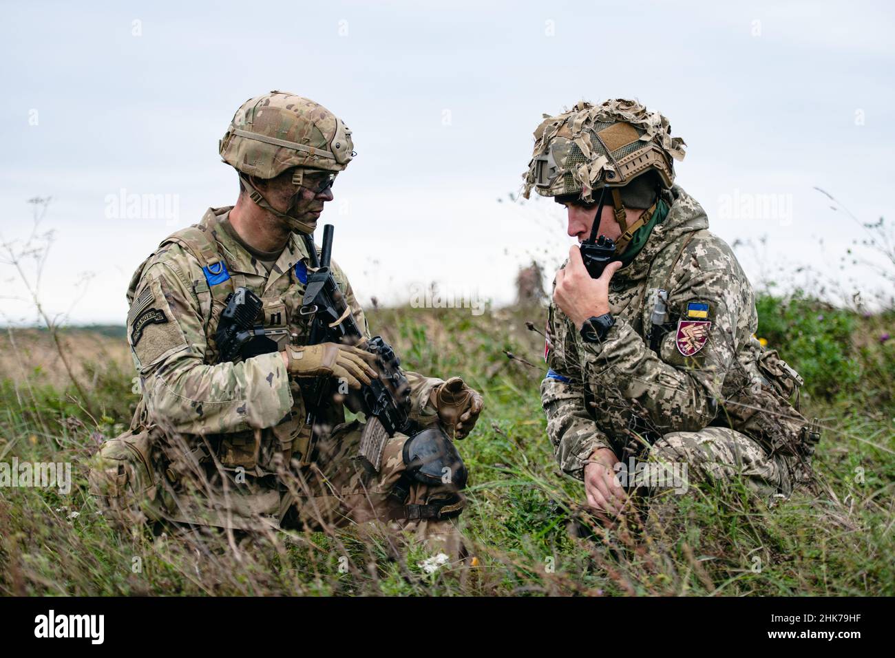 Yavoriv, Ucraina. 2nd Feb 2022. Un paracadutista dell'esercito degli Stati Uniti assegnato a 1st battaglione, il 503rd Parachute Fanteria Regiment coordina l'istituzione di una posizione di sicurezza congiunta su una zona di caduta con un paracadutista della Brigata Lituana - Polacca - Ucraina dopo aver condotto un'operazione congiunta di trasporto aereo. Questa formazione fa parte dell'esercizio Rapid Trident 21 presso l'International Peacekeeping Security Center nelle vicinanze Foto Stock