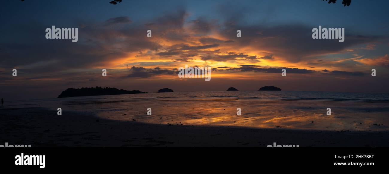 Panorama di tramonto spettacolare sulla spiaggia con colori luminosi e nessuna gente su albero di palma Isola di Koh Chang, Thailandia. Foto Stock