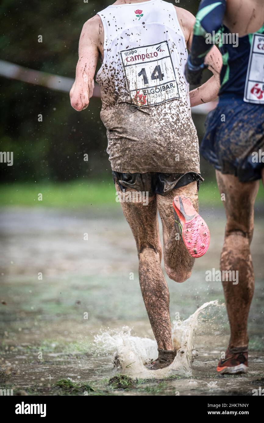 Gambe dell'atleta che corrono in un Cross Country tra acqua e fango, pure Cross. Foto Stock