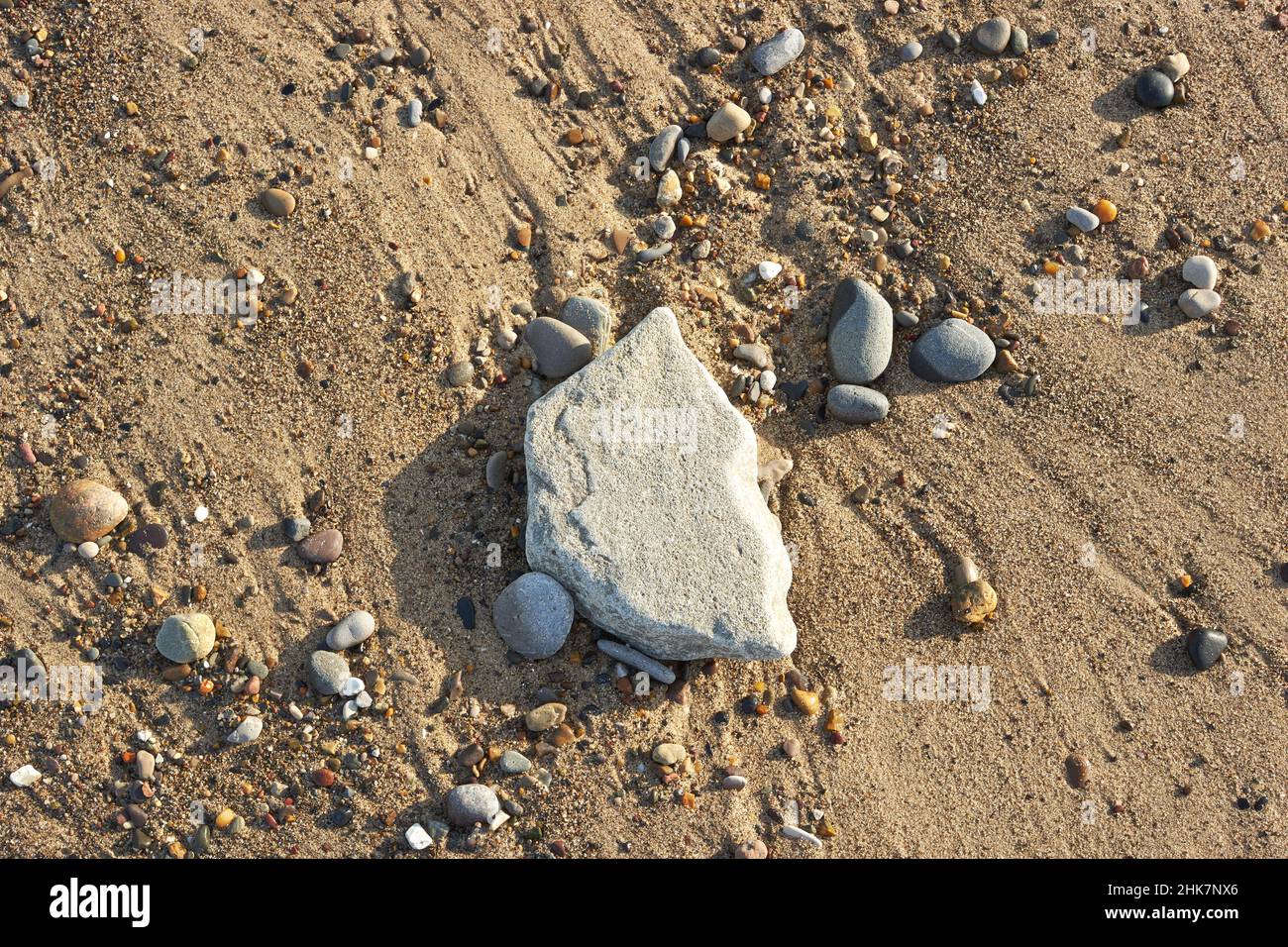 Roccia su una spiaggia dopo l'alta marea Foto Stock