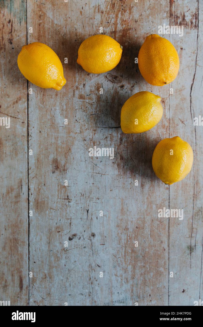 Cinque limoni su sfondo di legno Foto Stock