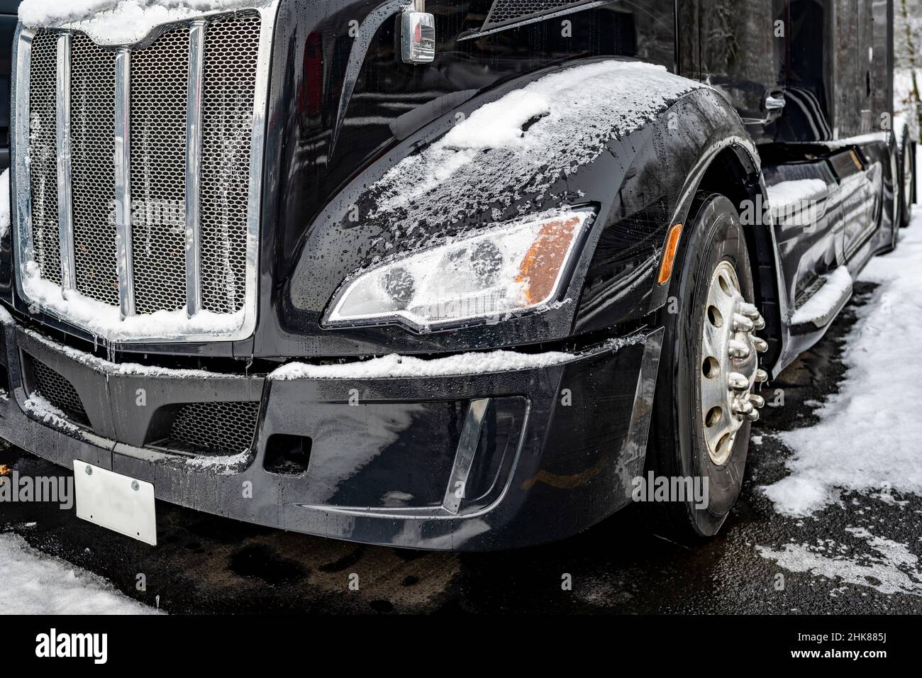Trattore semi-camion classico Black Big RIG con griglia cromata e accessori in piedi per il conducente del veicolo sul parcheggio arresto carrello industriale co Foto Stock