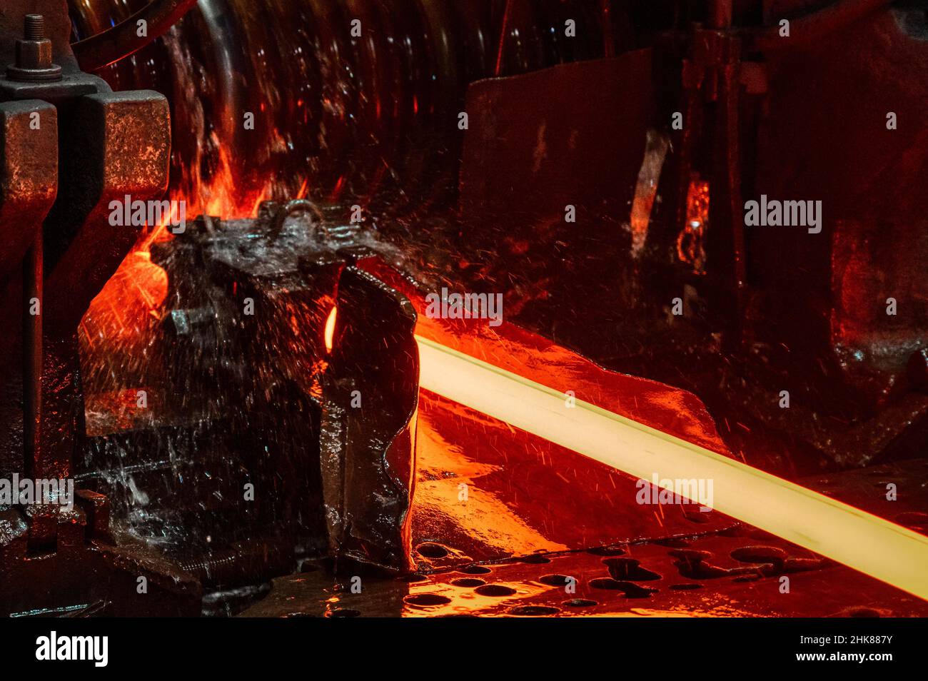 Il laminatoio in funzione. Il metallo caldo viene fatto rotolare attraverso rulli raffreddati Foto Stock