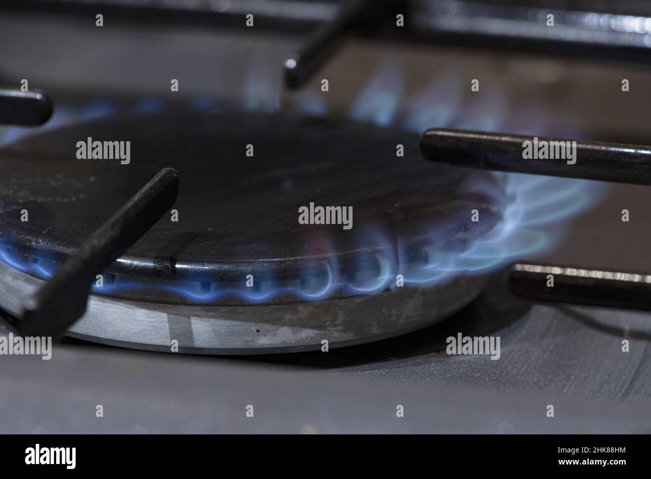 Un anello di gas su un fornello con fiamme crescenti che si innalzano a destra Foto Stock
