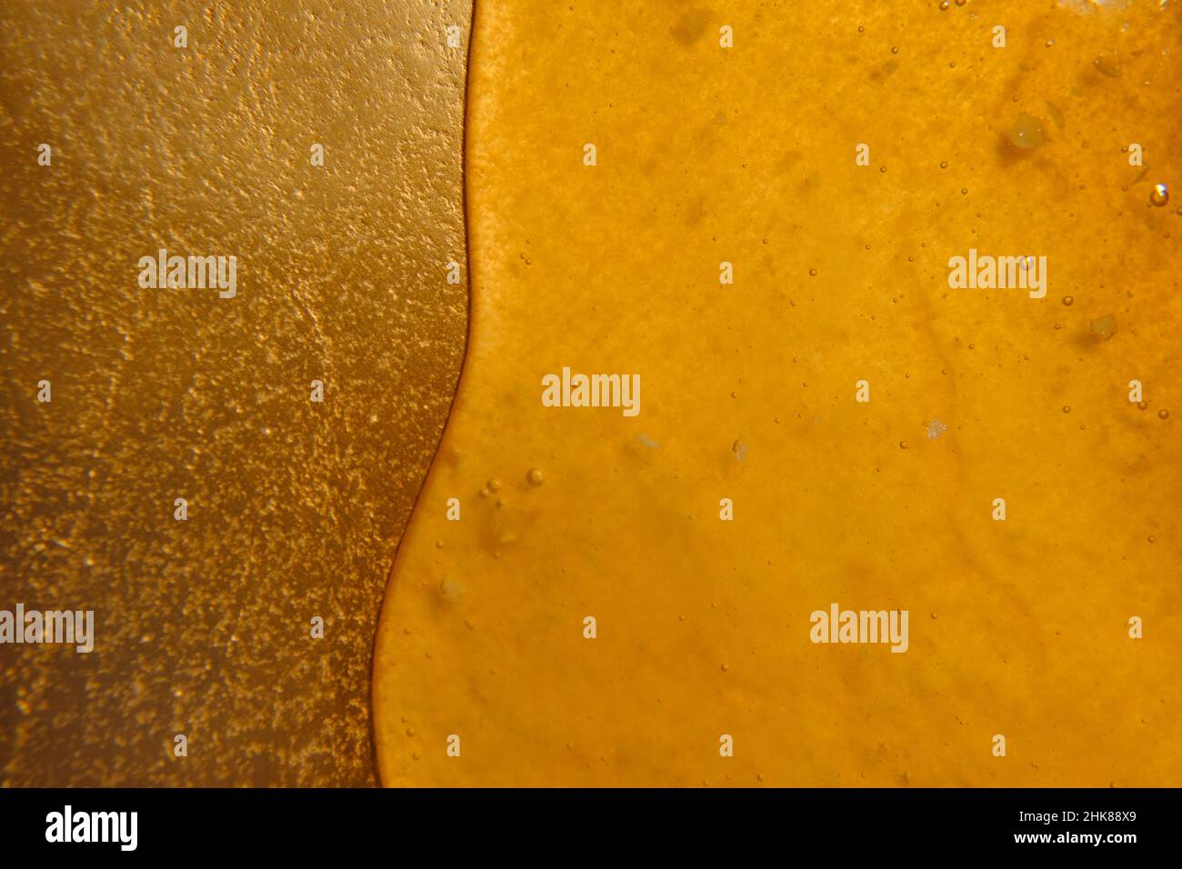 Miele gocciola su un vassoio d'oro naturale apicoltura products.Texture di miele.Liquid miele. Foto Stock