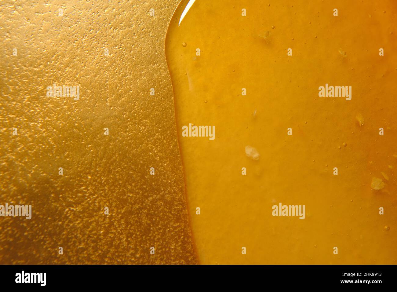 Honey. Texture di miele. Miele liquido. Primo piano miele gocciolare su un vassoio d'oro naturale apicoltura prodotti. Foto Stock