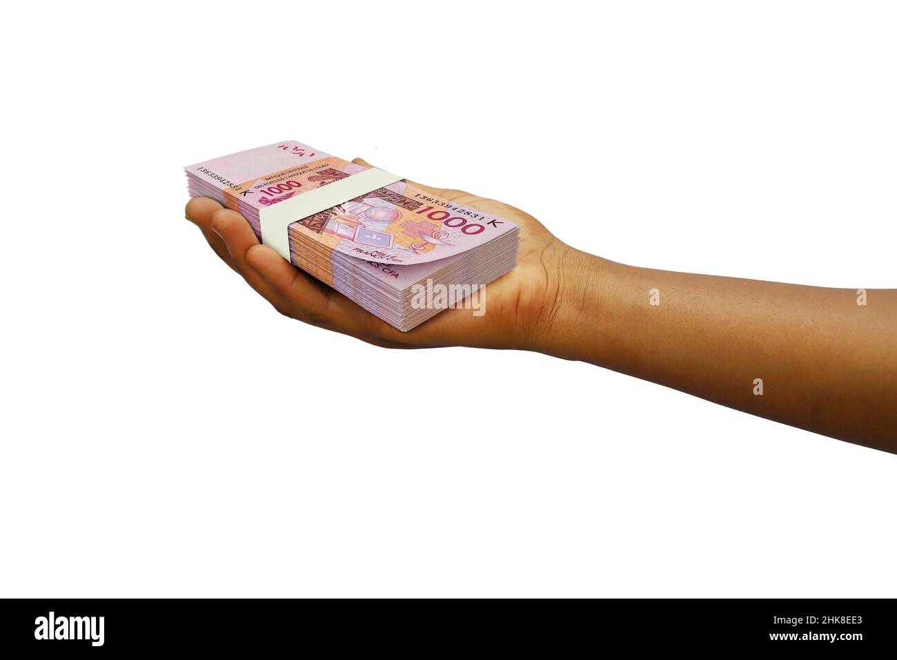 Hand Holding 3D reso stack di note CFA Franc isolato su sfondo bianco Foto Stock