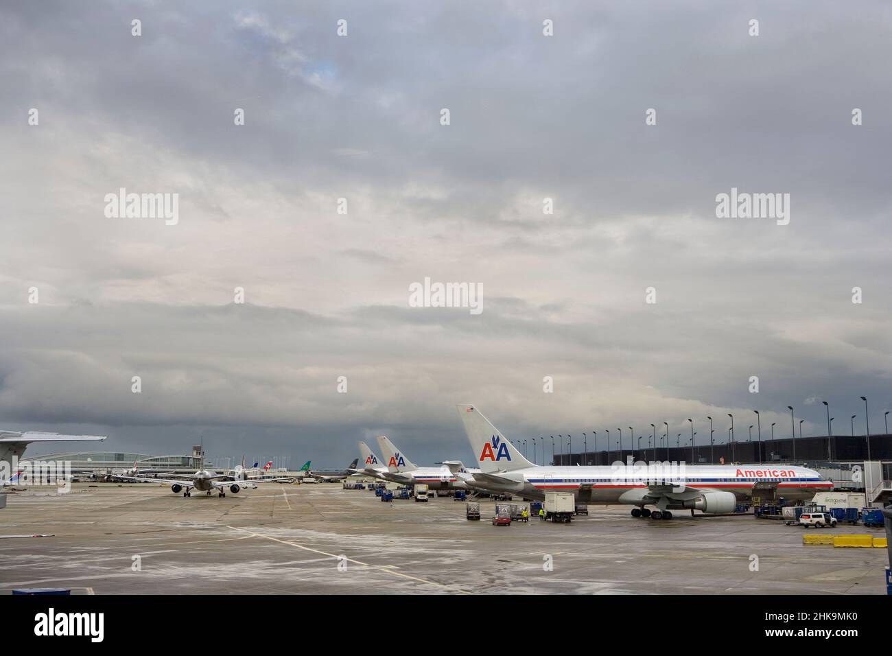 Velivoli allineati in distanza sul tarmac dopo la pioggia Foto Stock